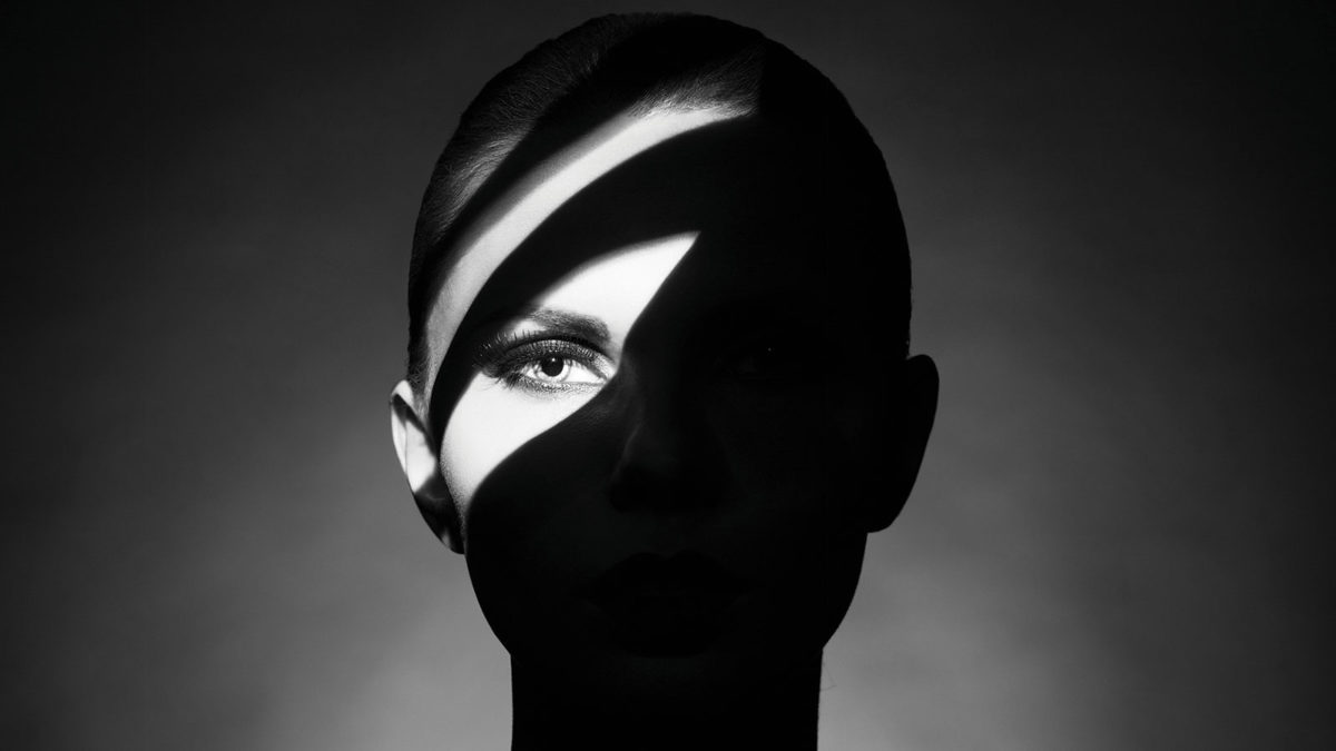 Woman in dark with one eye in light