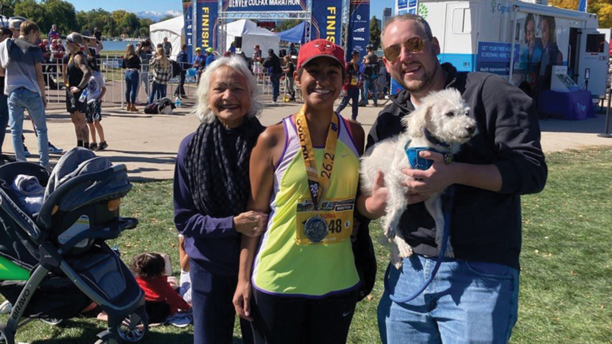 Sonia celebrates with her mother Kusum Prabhakar, husband Don McGinnis, and dog Milo after running the 2021 Colfax Marathon.