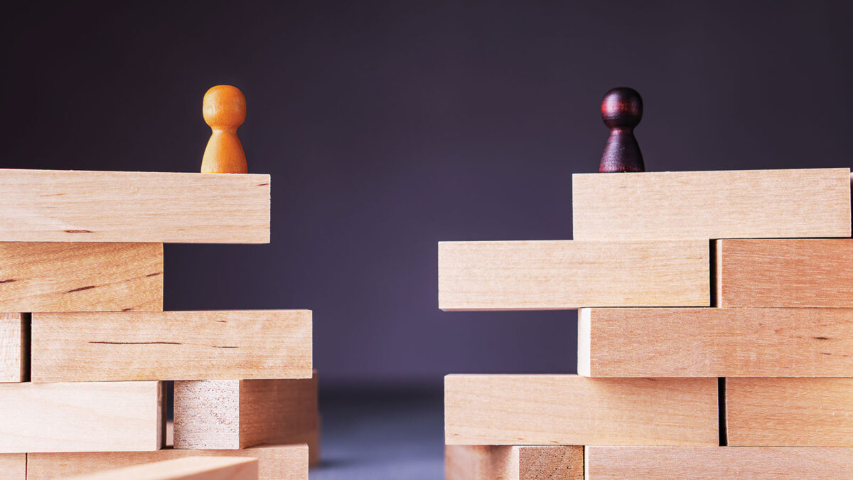 Two people pegs on Jenga blocks facing each other